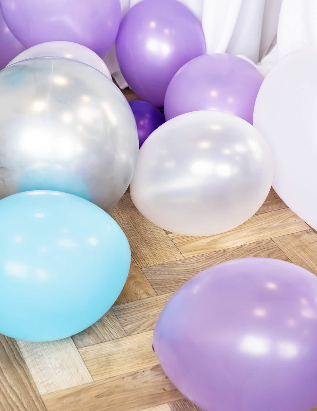 Opstelling op de grond van metallische ballonnen voor feest wit parelmoer