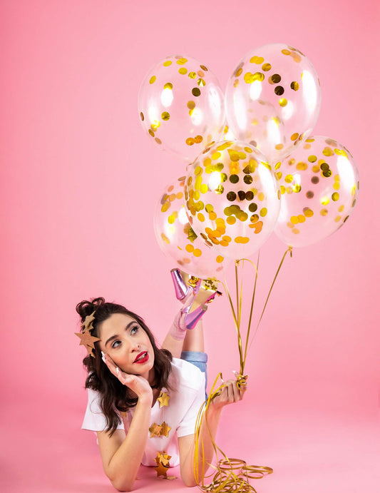 Mise en situation du ballon transparent à confettis pour fête avec confettis dorés