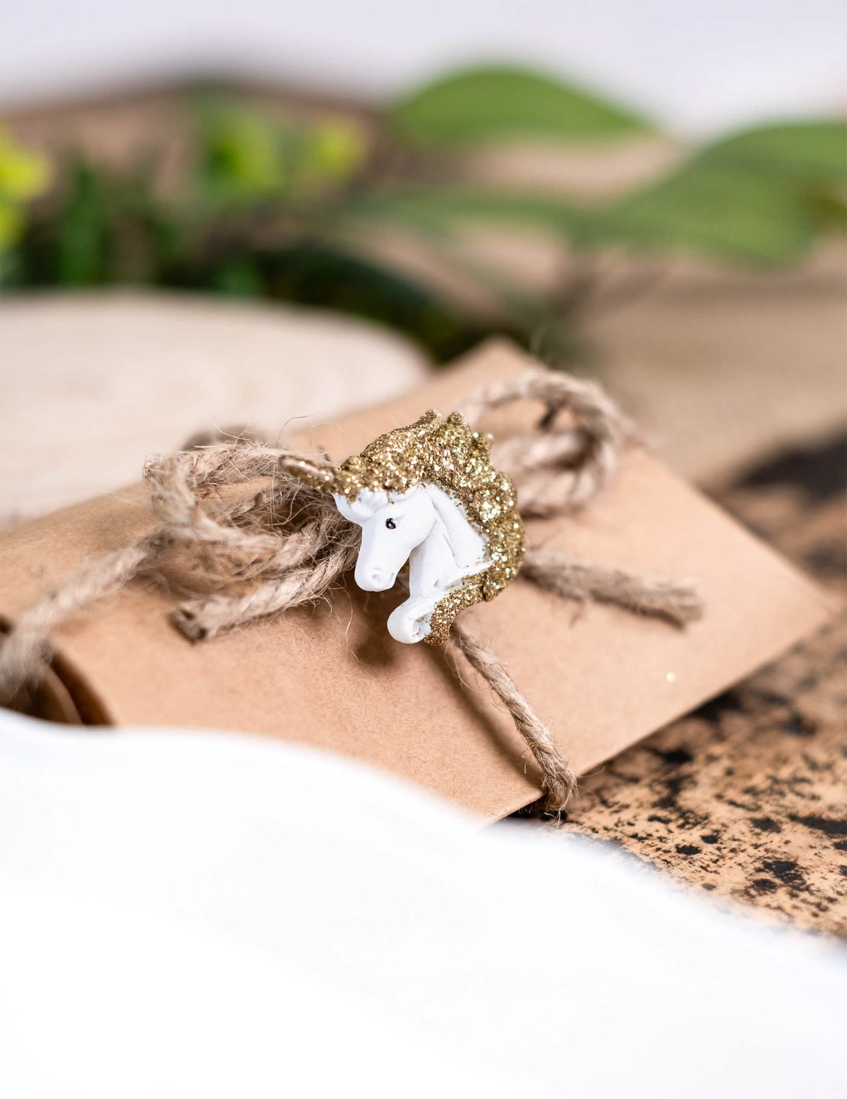Zoom sur une licorne décorant une pochette des licornes adhésives en résine blanches et paillettes dorées