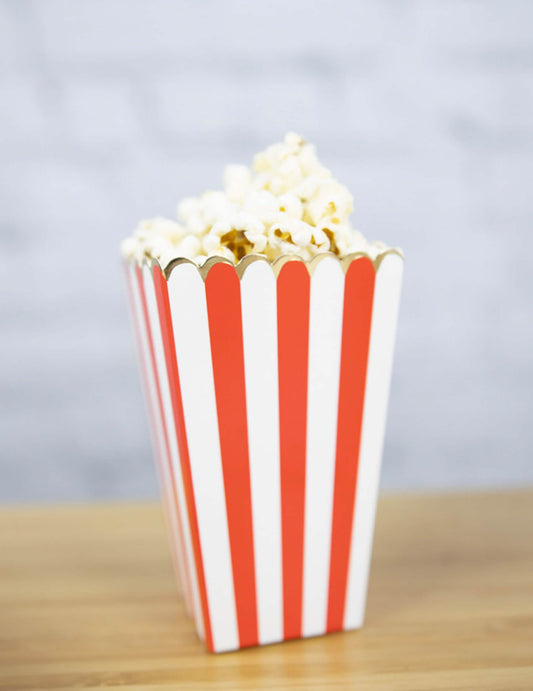 Vue d'une boîte remplie de popcorn des boîtes à popcorn à rayures pour fête rouges et blanches avec liseré doré