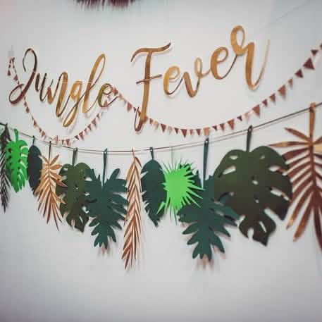 Détail des feuilles et du lettrage doré de la guirlande en carton jungle fever pour anniversaire tropical