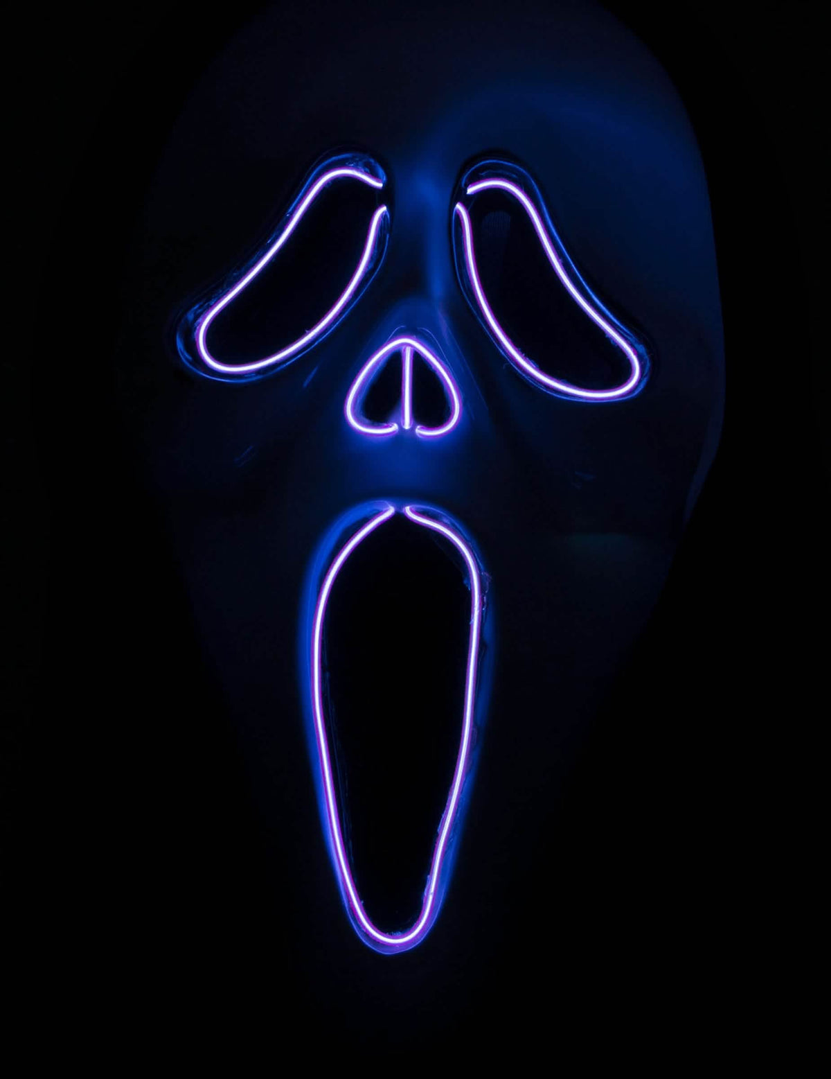 Détail des contours LED allumés dans le noir du masque LED fantôme hurlant