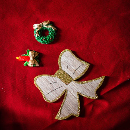Détail des motifs pailletés or des 12 nœuds en bois de Noël