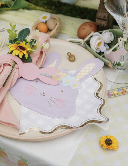 Mise en scène de table des serviettes en papier à motifs carreaux pour fête lilas rose jaune vert et bordure or ondulée