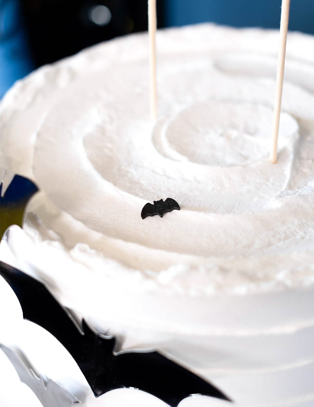 Détail d'un confetti posé sur un gâteau des 20 confettis de table chauve-souris Halloween noir