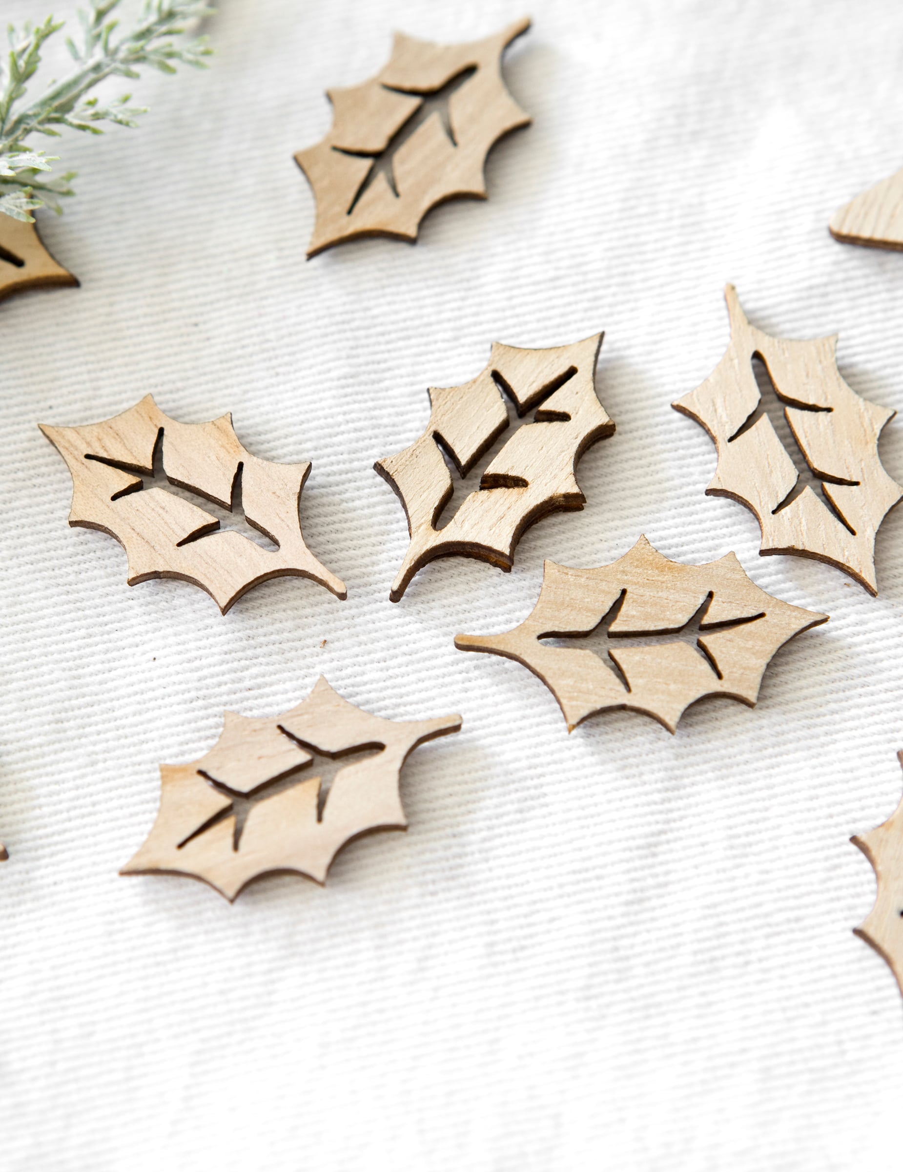 Vue rapprochée des confettis en bois ajouré feuilles de houx pour noël