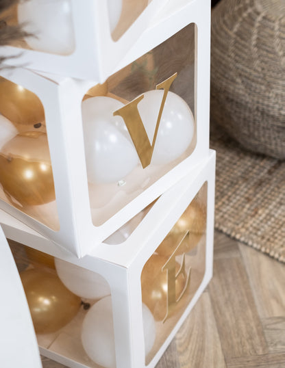 Gros plan sur les lettres dorées des cubes à ballons pour décoration personnalisable