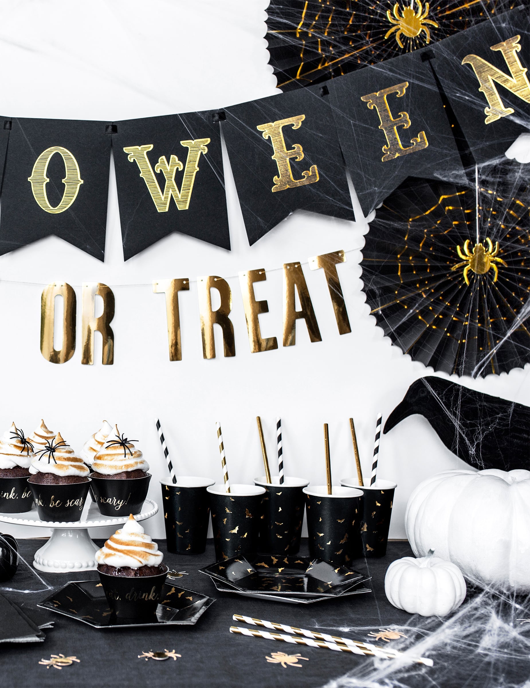 Mise en scène sur une table décorée des gobelets en carton chauve-souris pour Halloween
