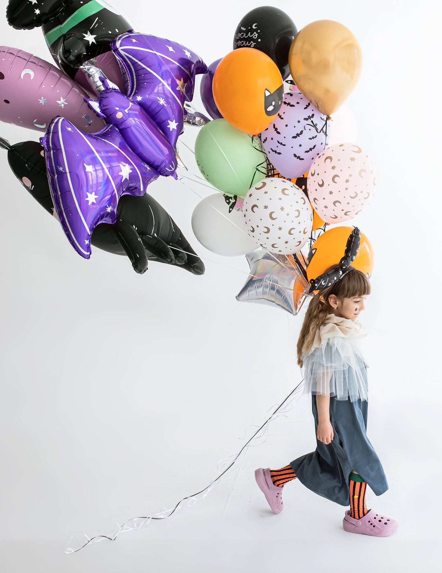 Vue de profil d'une enfant avec le ballon aluminium géant chauve-souris pour Halloween
