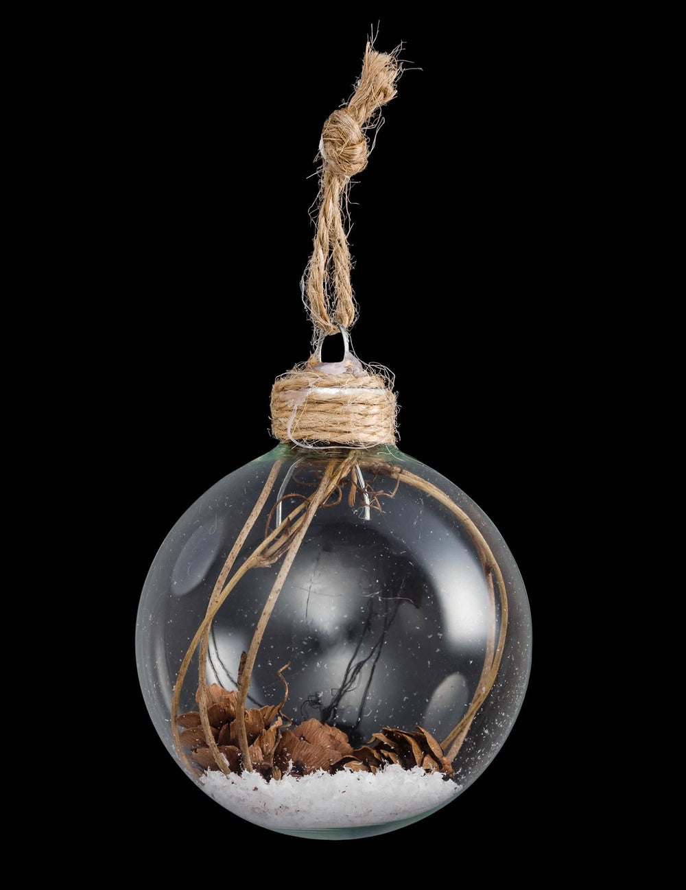 Vue de face de la boule de Noël en verre avec pommes de pin et neige