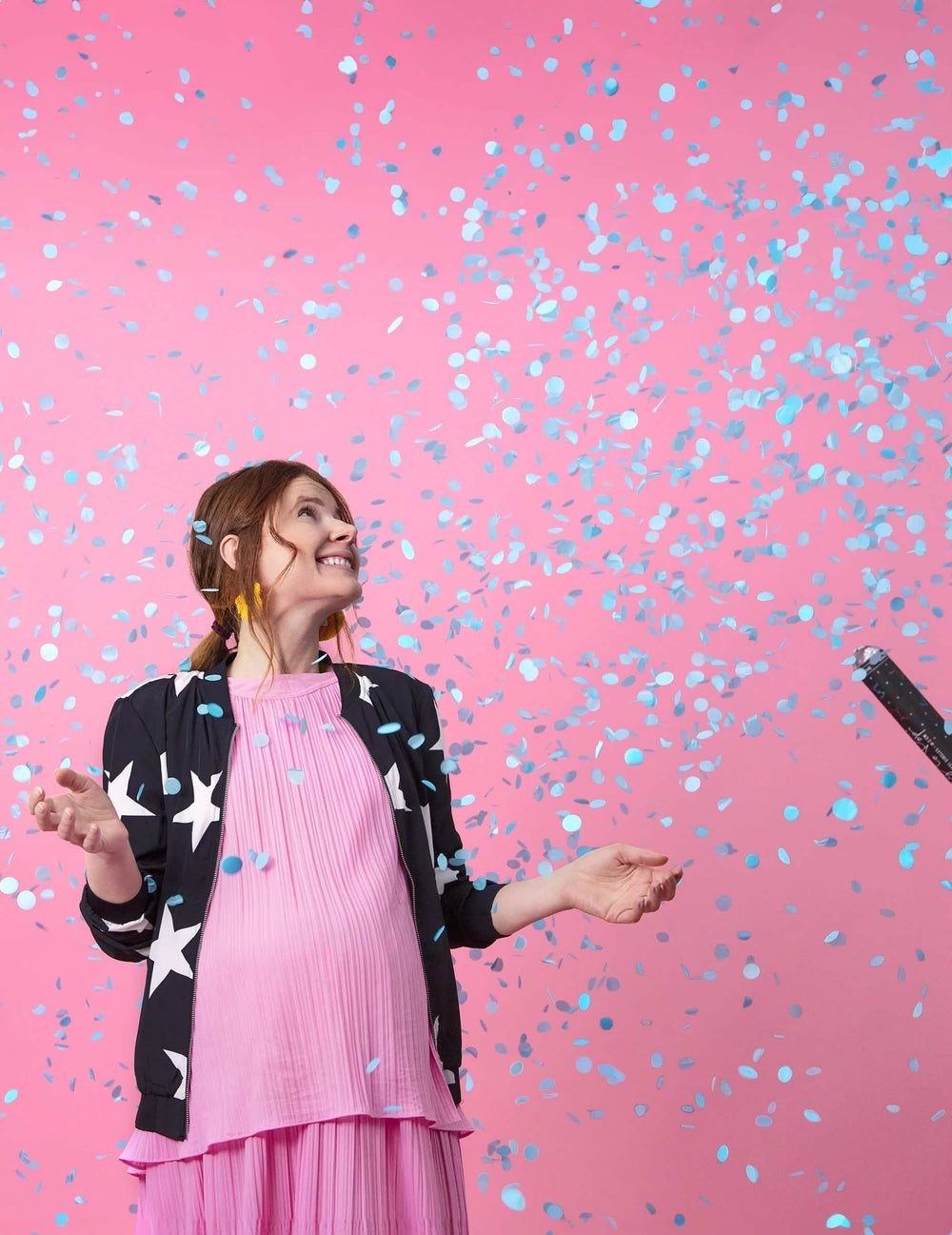 Pluie de confettis bleus sur une femme enceinte du canon à confettis boy pour baby shower