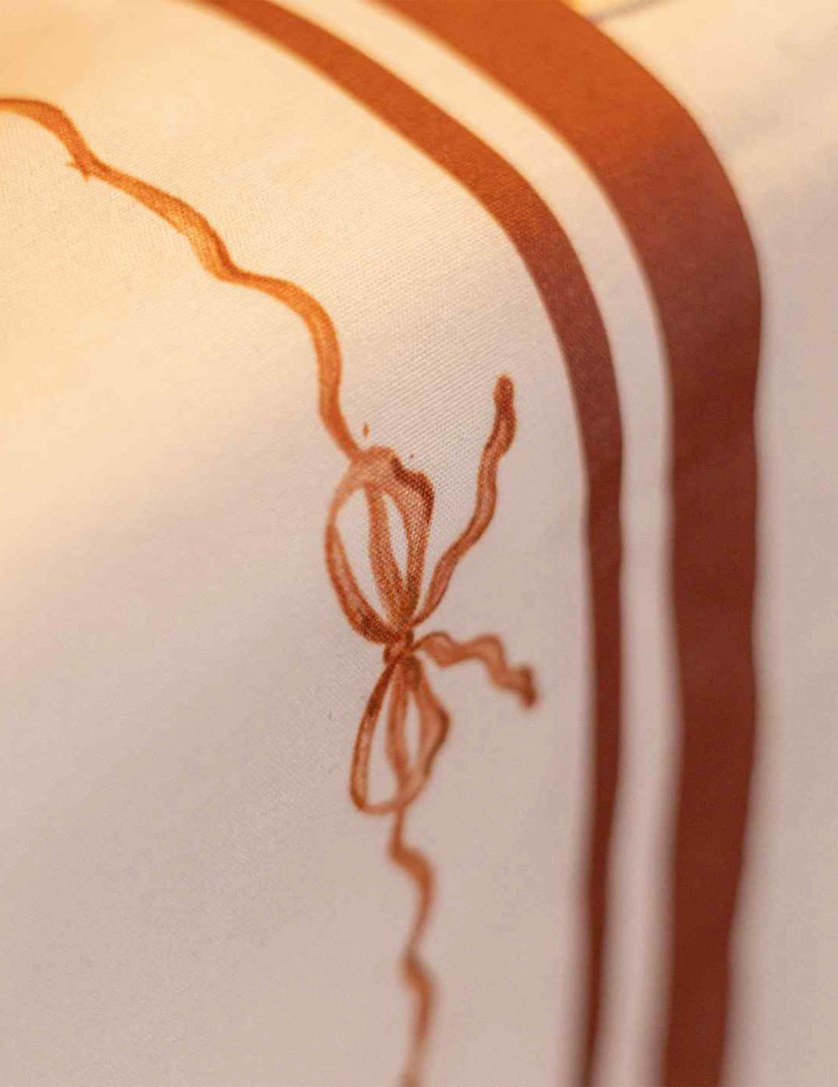Chemin de table Jolis Nuds en tissu crème auburn et terre brûlée 28 cm x 3 m