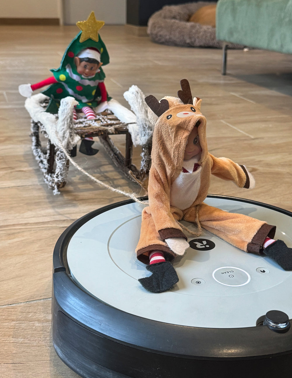 Mise en scène sur un aspirateur robot du déguisement renne de Noël pour poupée lutin farceur