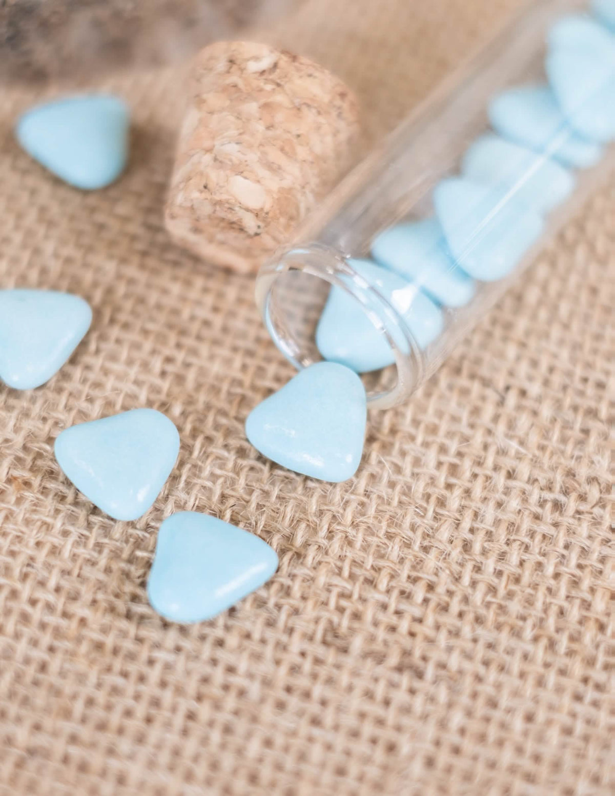 Détail des dragées sortant d'une éprouvette du Dragées mini coeur chocolat pour communion