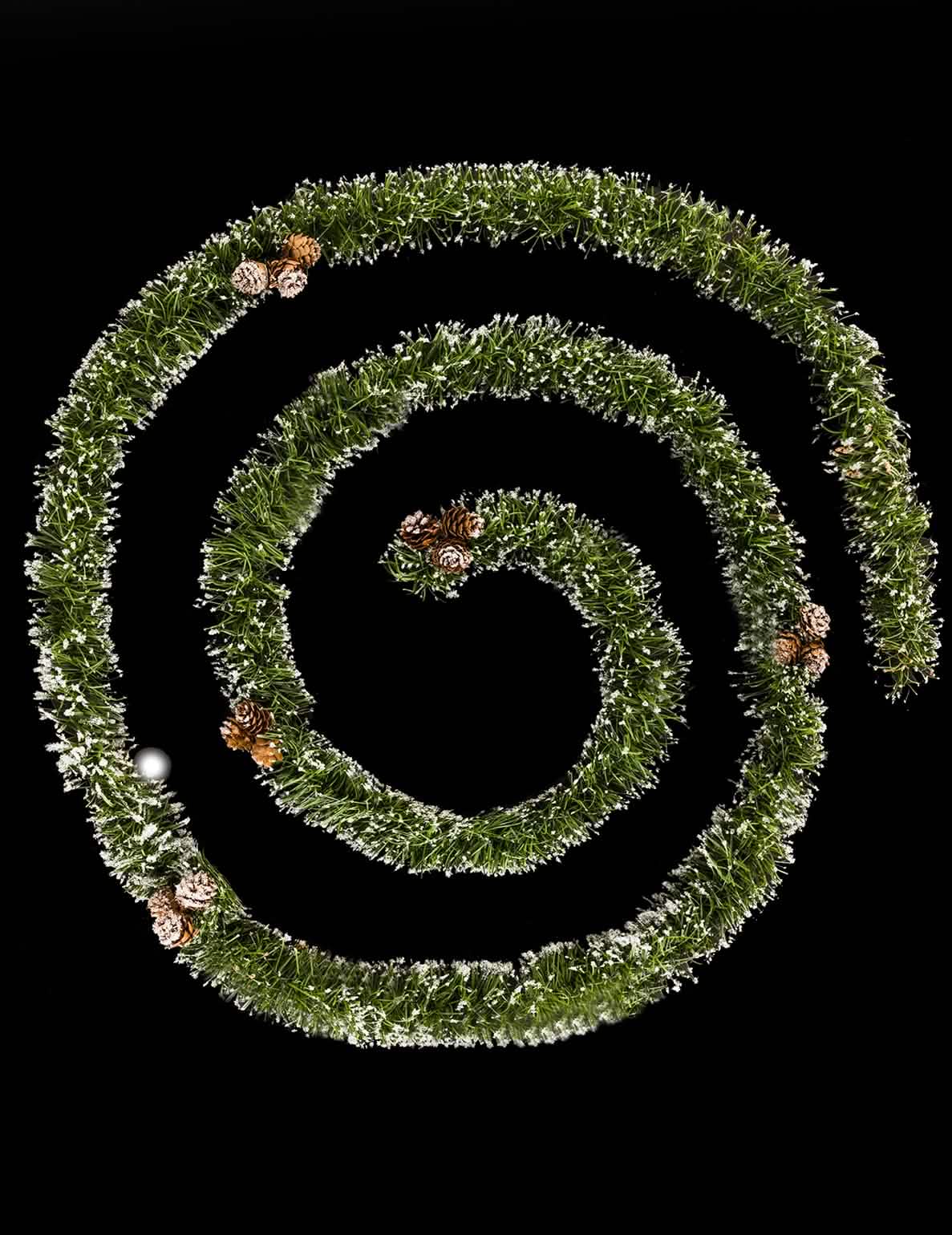 Guirlande van groene natuurlijke dennendecoratie met dennenappels en besneeuwde punten