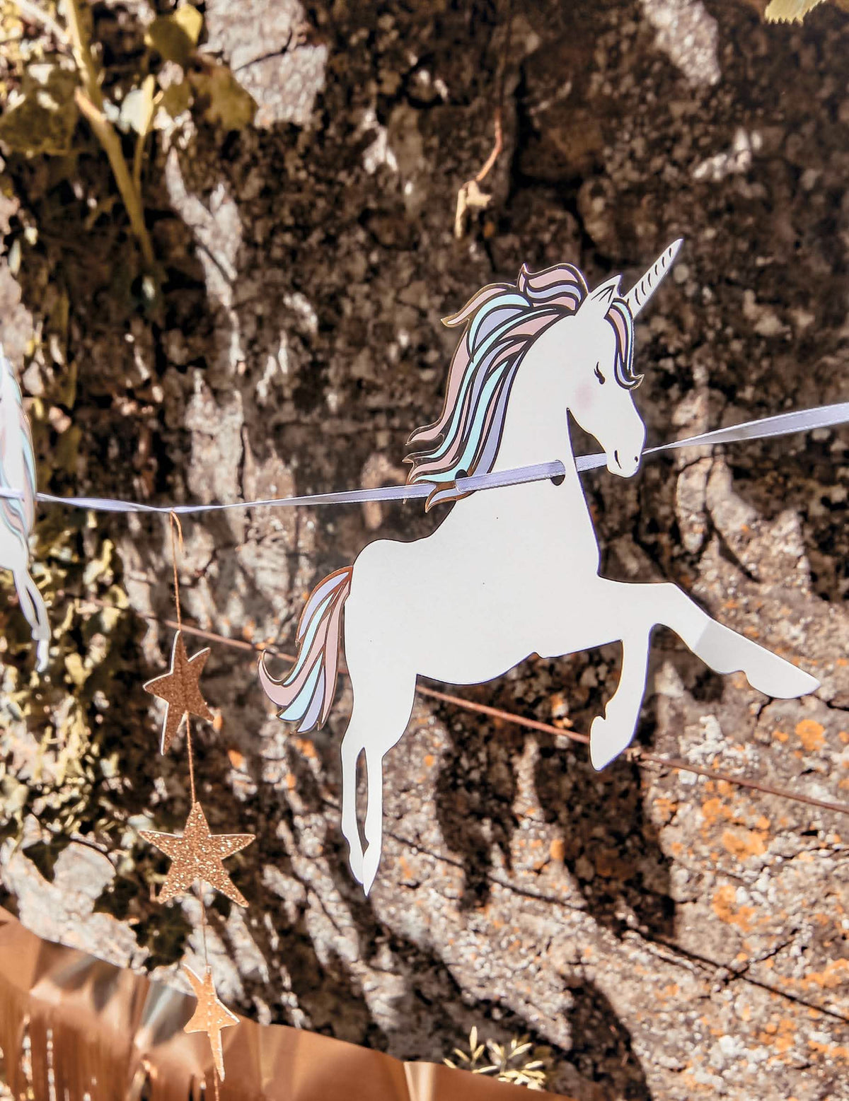 Gros plan sur le motif licorne de la guirlande licorne pastel et étoiles dorées