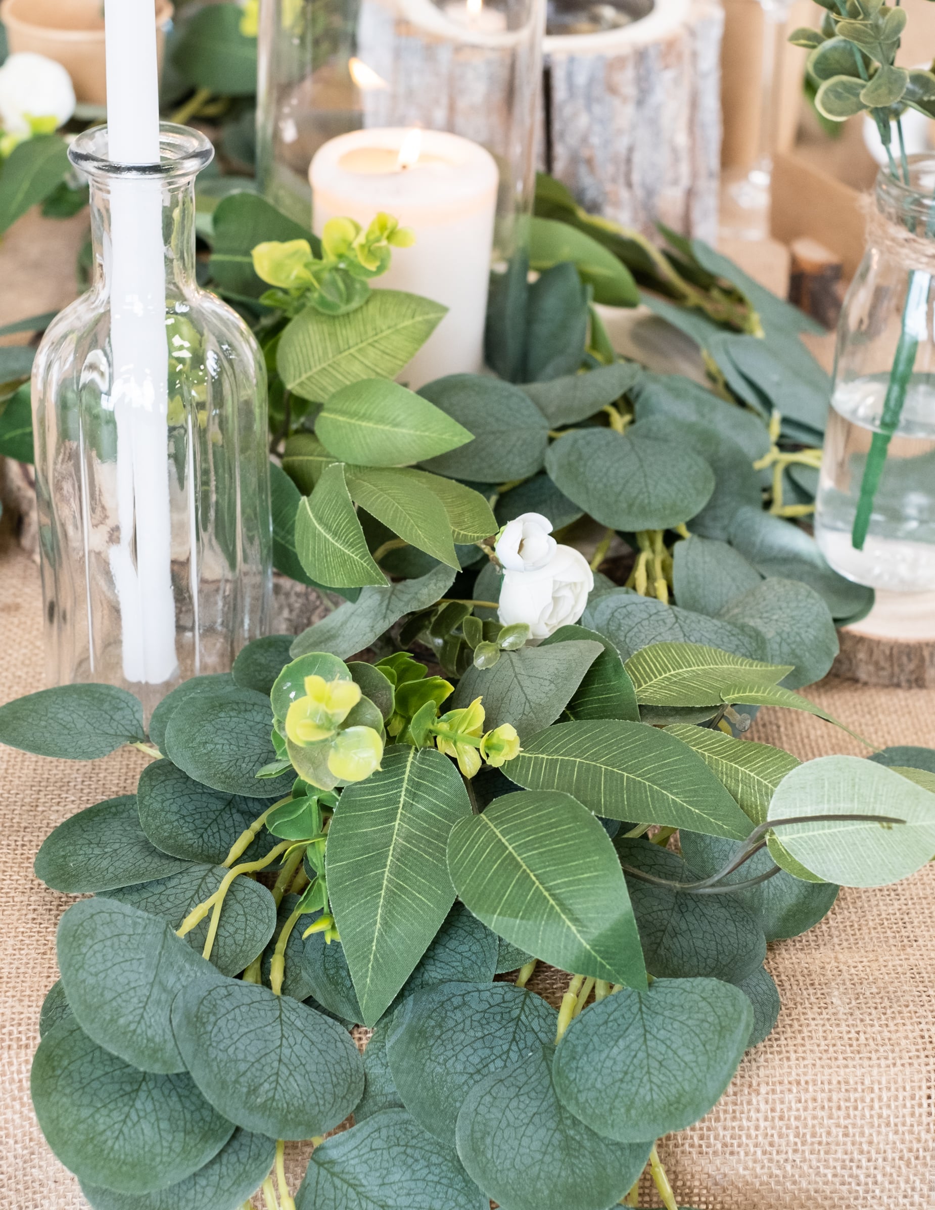 Gros plan sur le feuillage et les fleurs de la guirlande de pivoines, laurier et eucalyptus pour mariage blanche