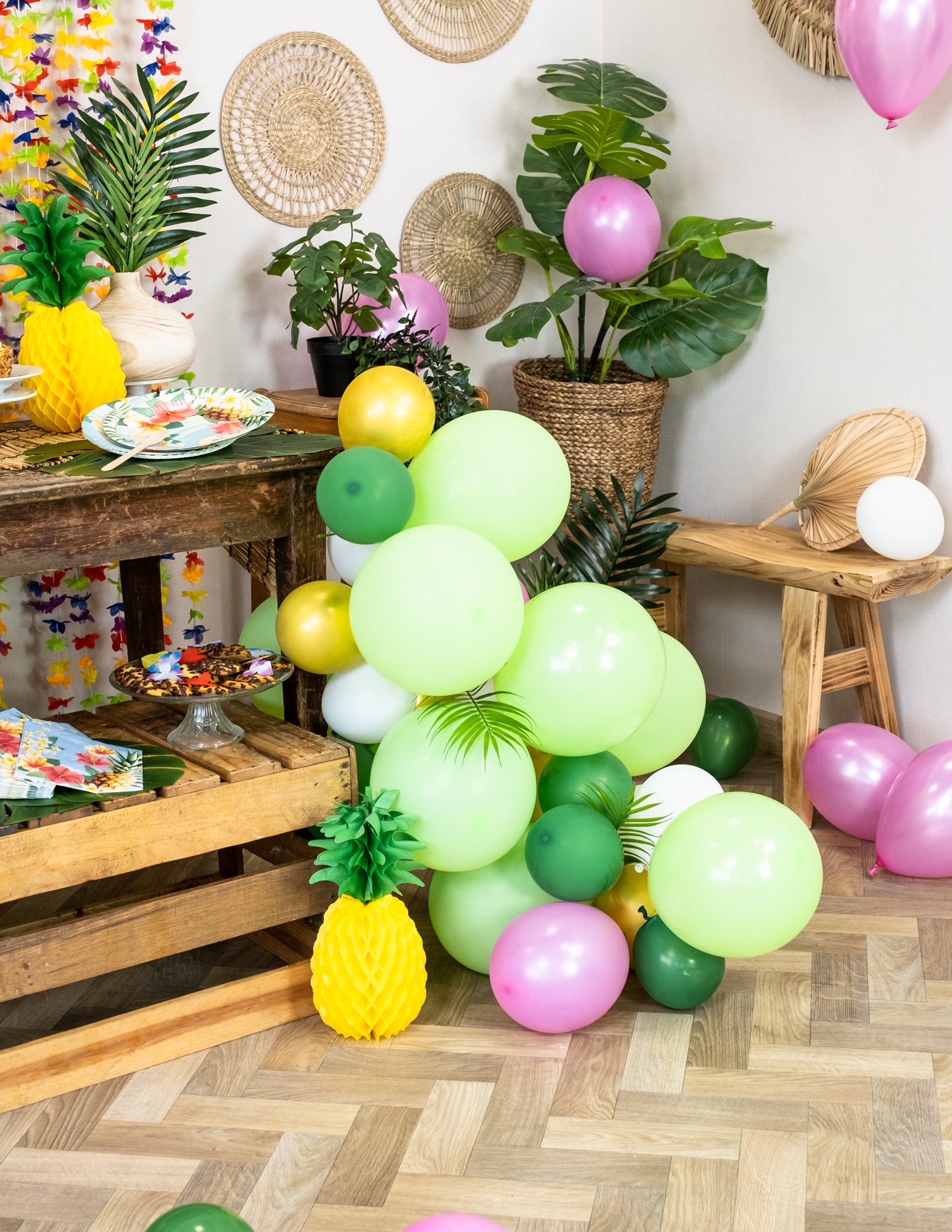 Détail des ballons et de l'ananas décoratif du kit arche de 70 ballons tropicale et feuilles jungle