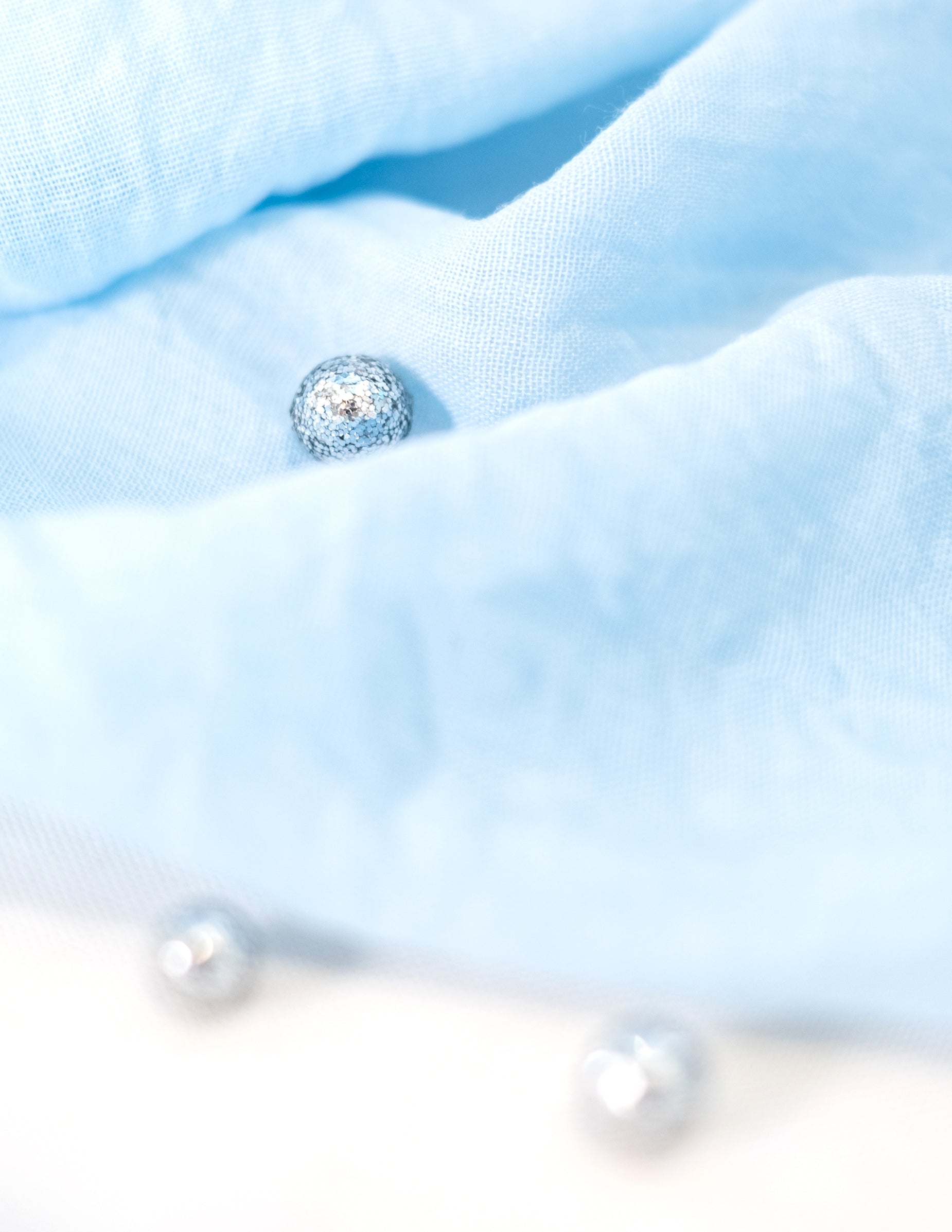 Détail de la texture des confettis de table mini boules pailletées argentées