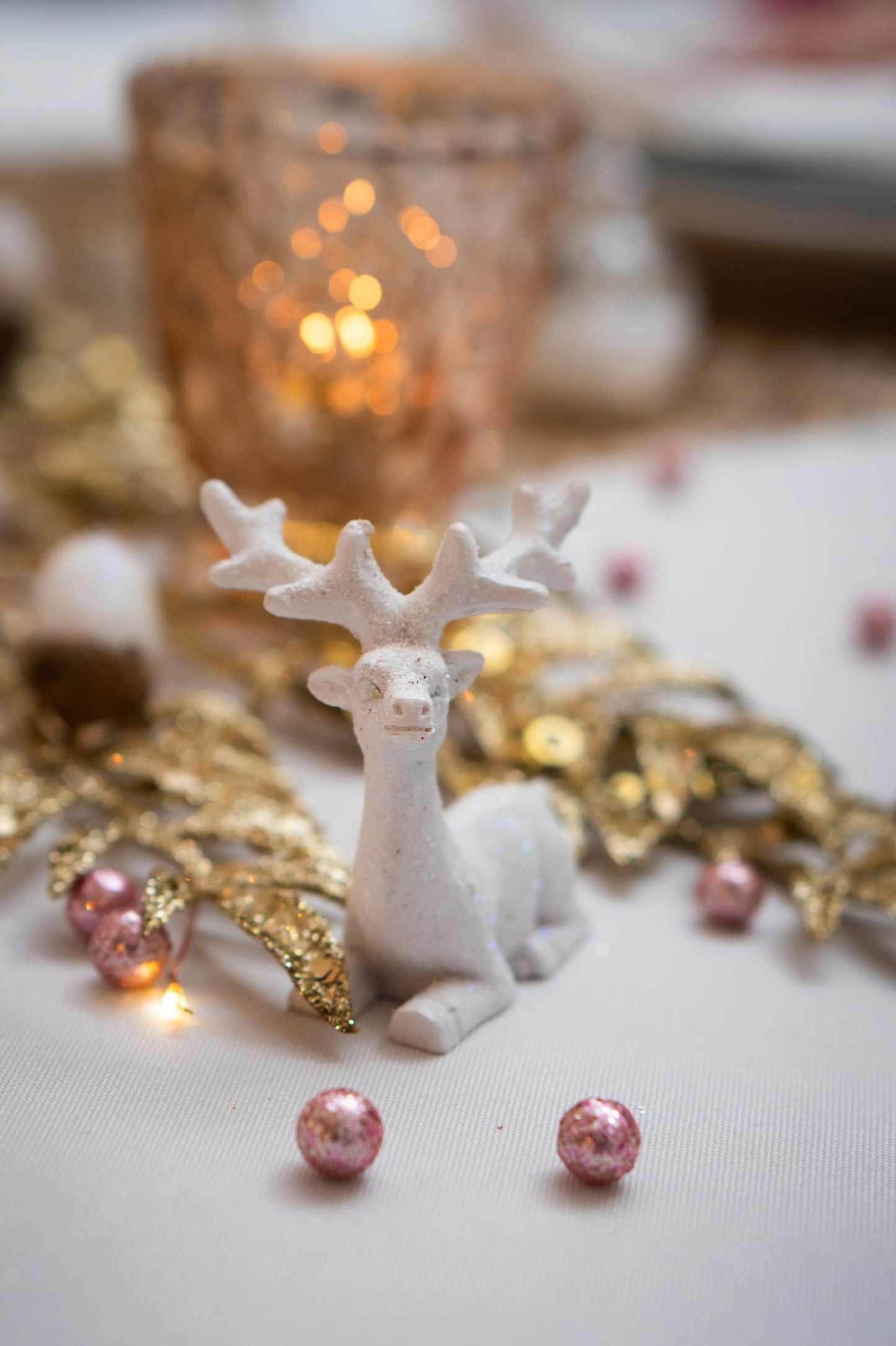 Détail de la mise en scène avec renne blanc des mini boules pailletées pour décoration rose gold
