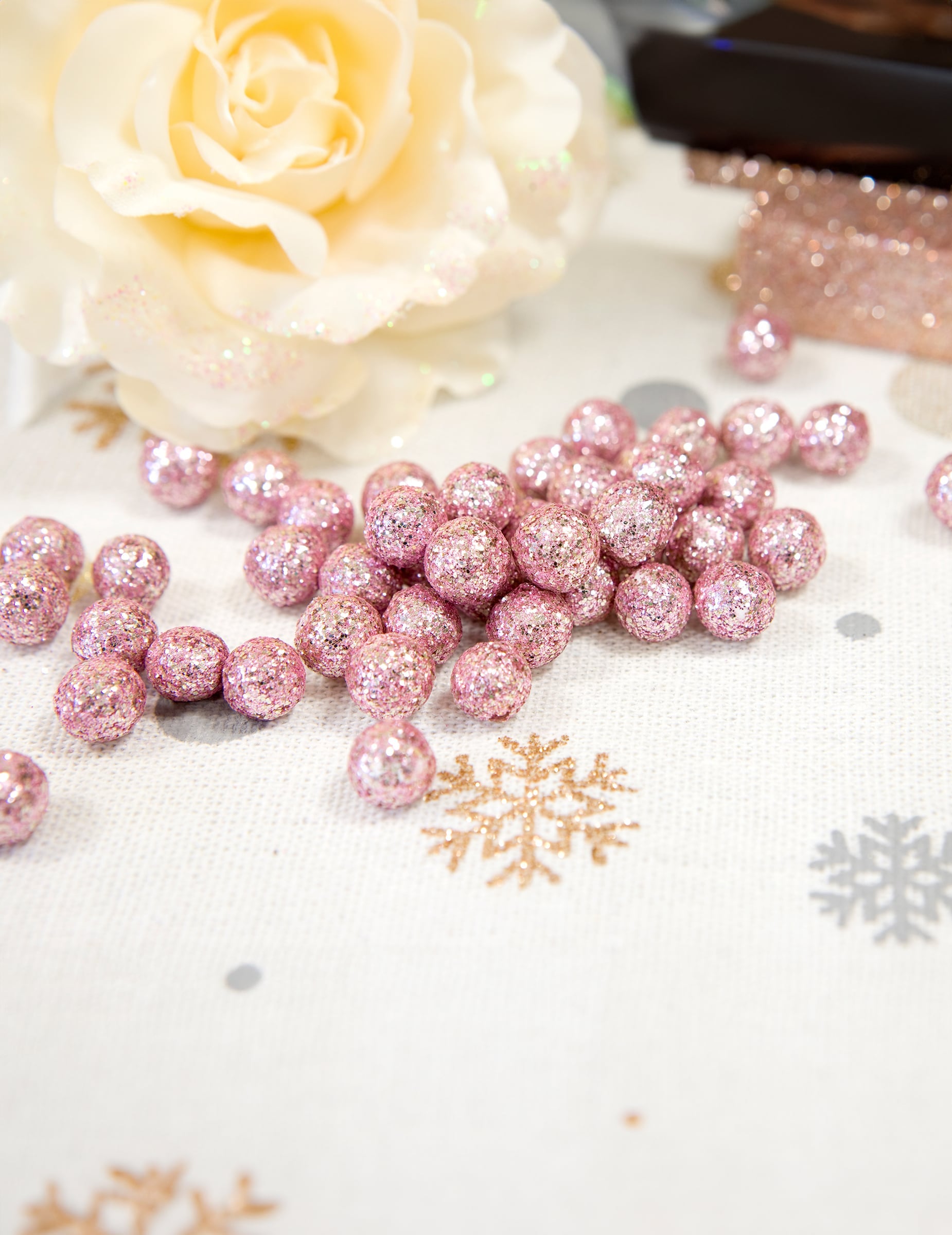 Détail de la mise en scène avec fleur blanche des mini boules pailletées pour décoration rose gold