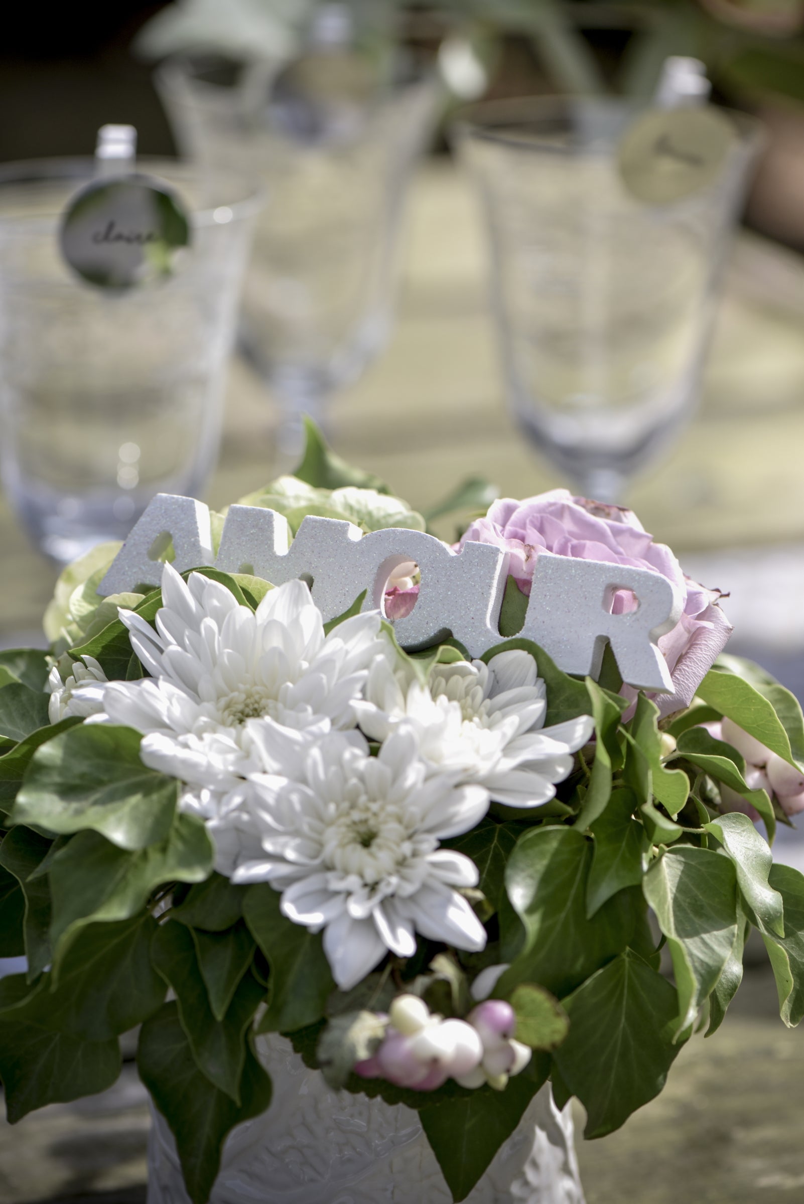 Gros plan au milieu de fleurs du mot en bois amour pour mariage blanc pailleté