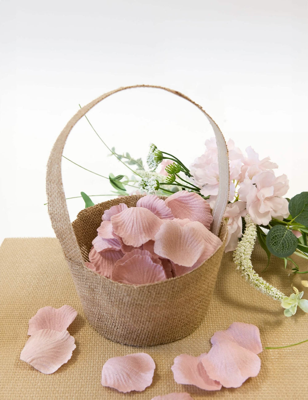 Gevulde mand met roze bloemblaadjes van de mand met jute-effect voor feest