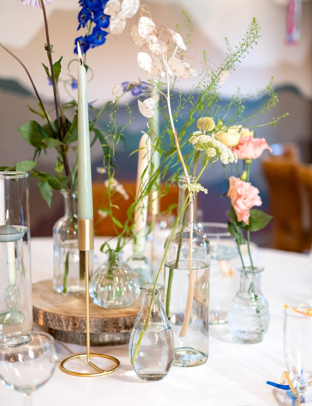 Composition florale avec bougies du vase soliflore en verre pour décoration de table